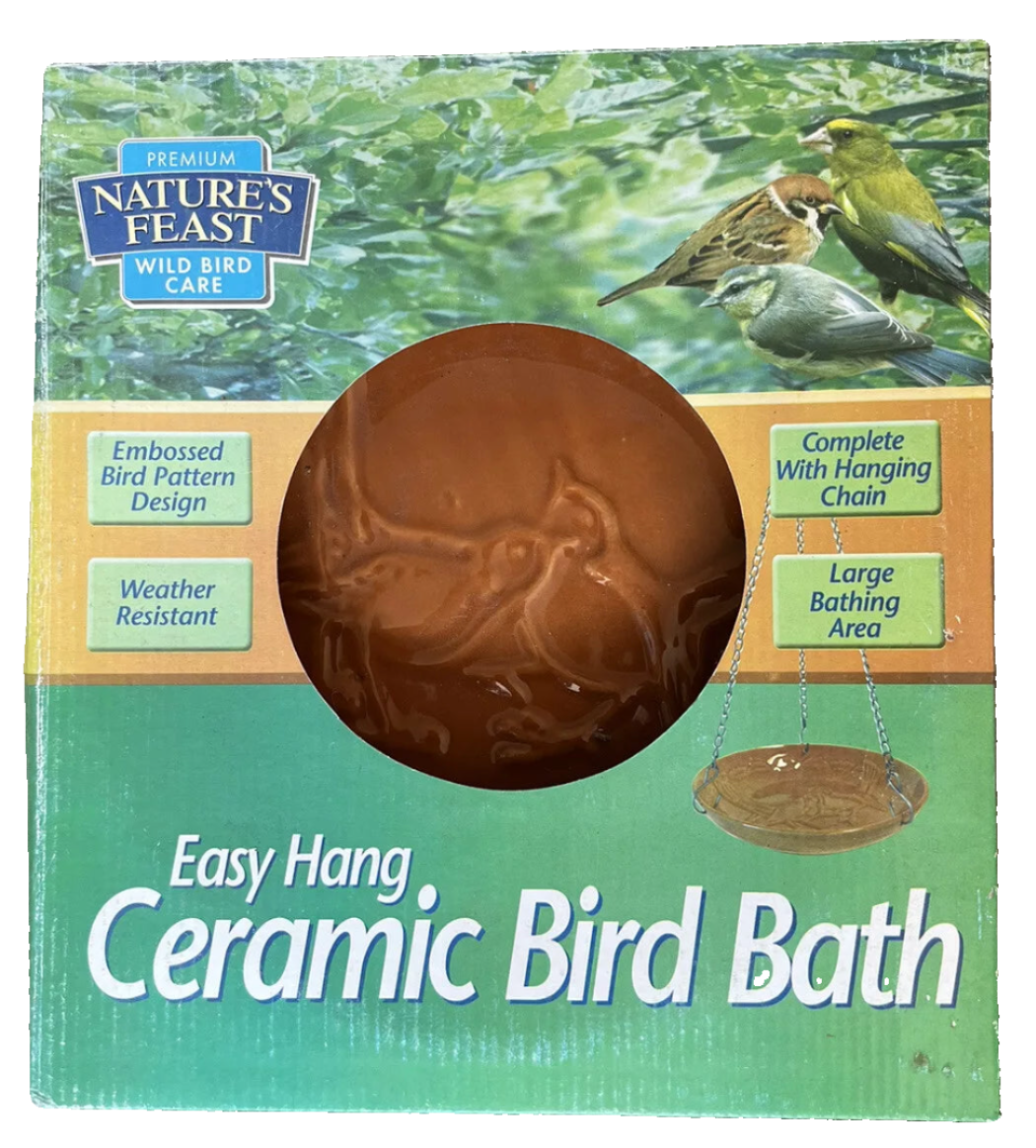 A brown ceramic bird bath with an embossed bird pattern, designed to be hung using a galvanised chain, displayed in its packaging which highlights features such as the large bathing area and weather resistance.